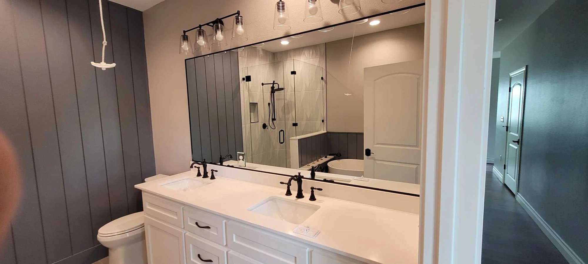 Ranaldo bathroom vanity with wall paneling and decorative lighting